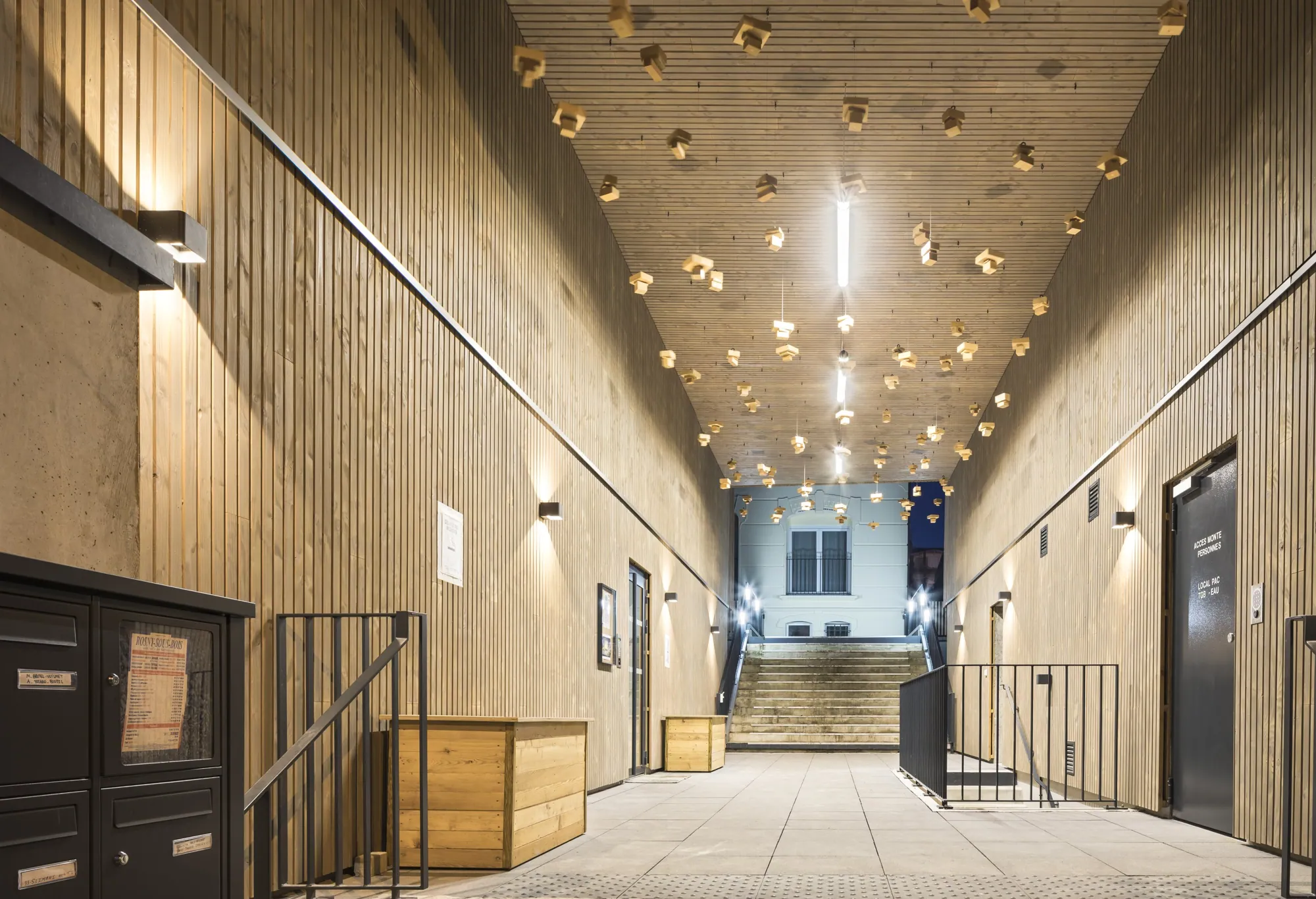 Hall d'entrée en bois avec suspentes en réemploi